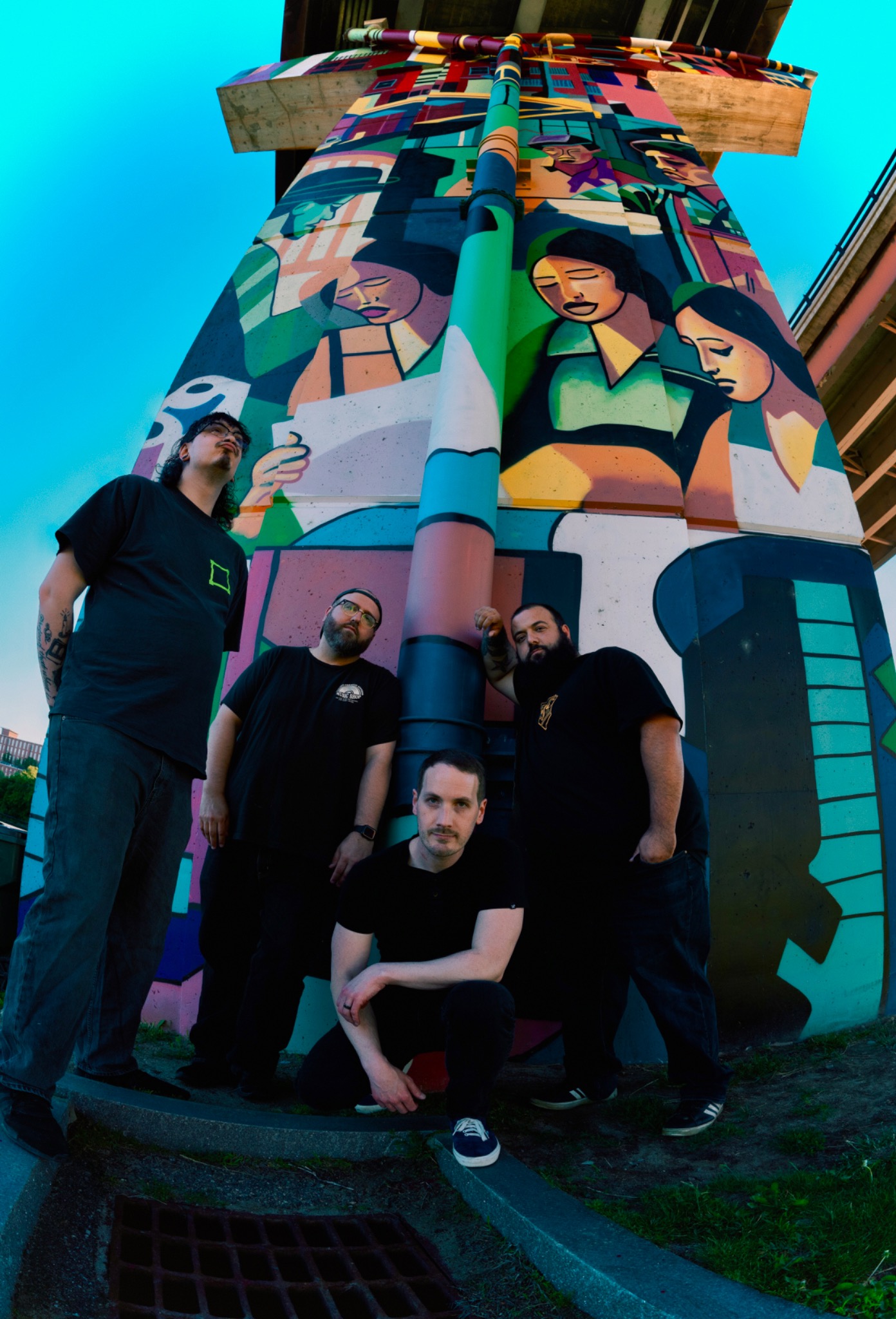 House Lights posed in front of a colorful mural