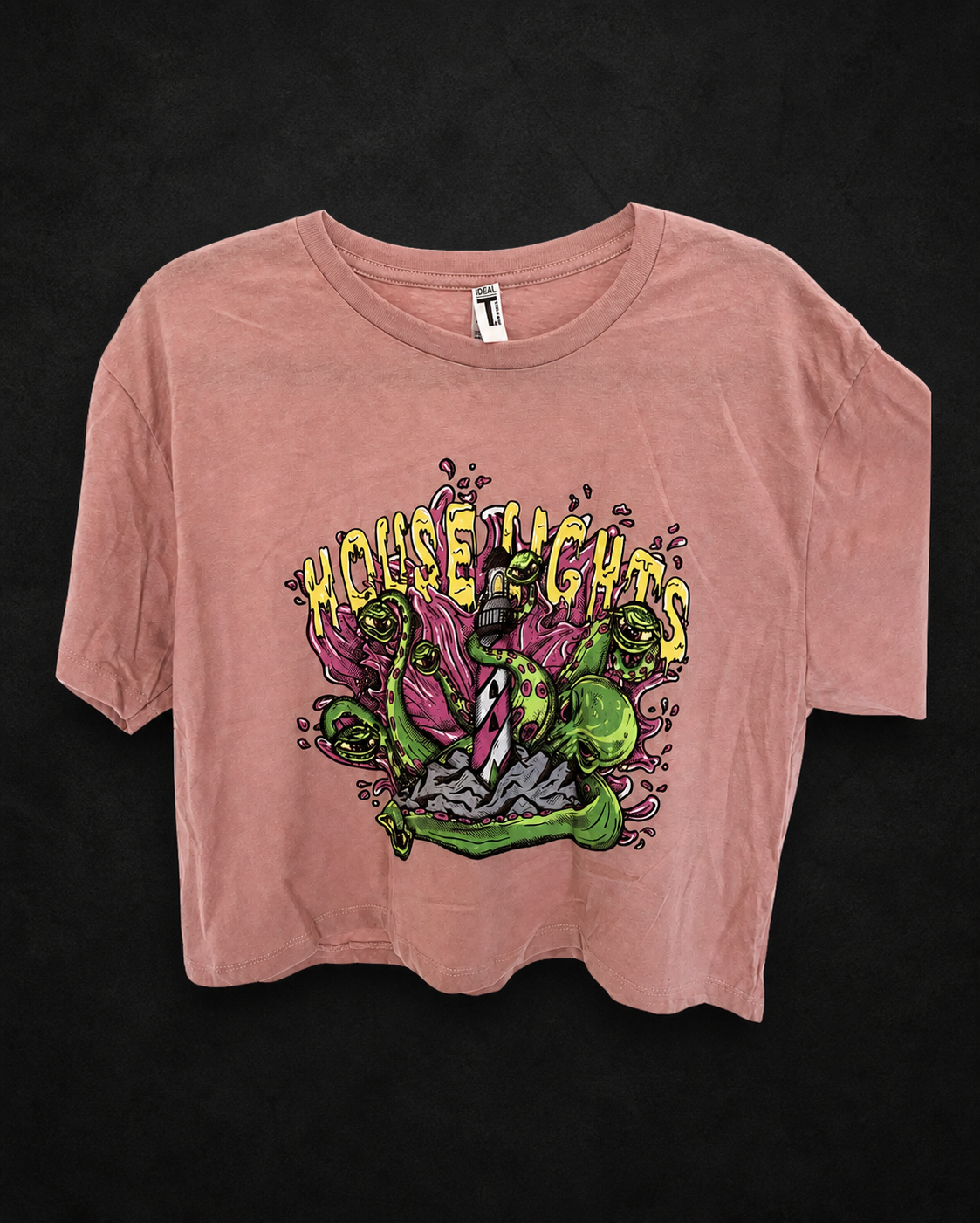 Pink Kraken Crop Top hanging on a textured black background